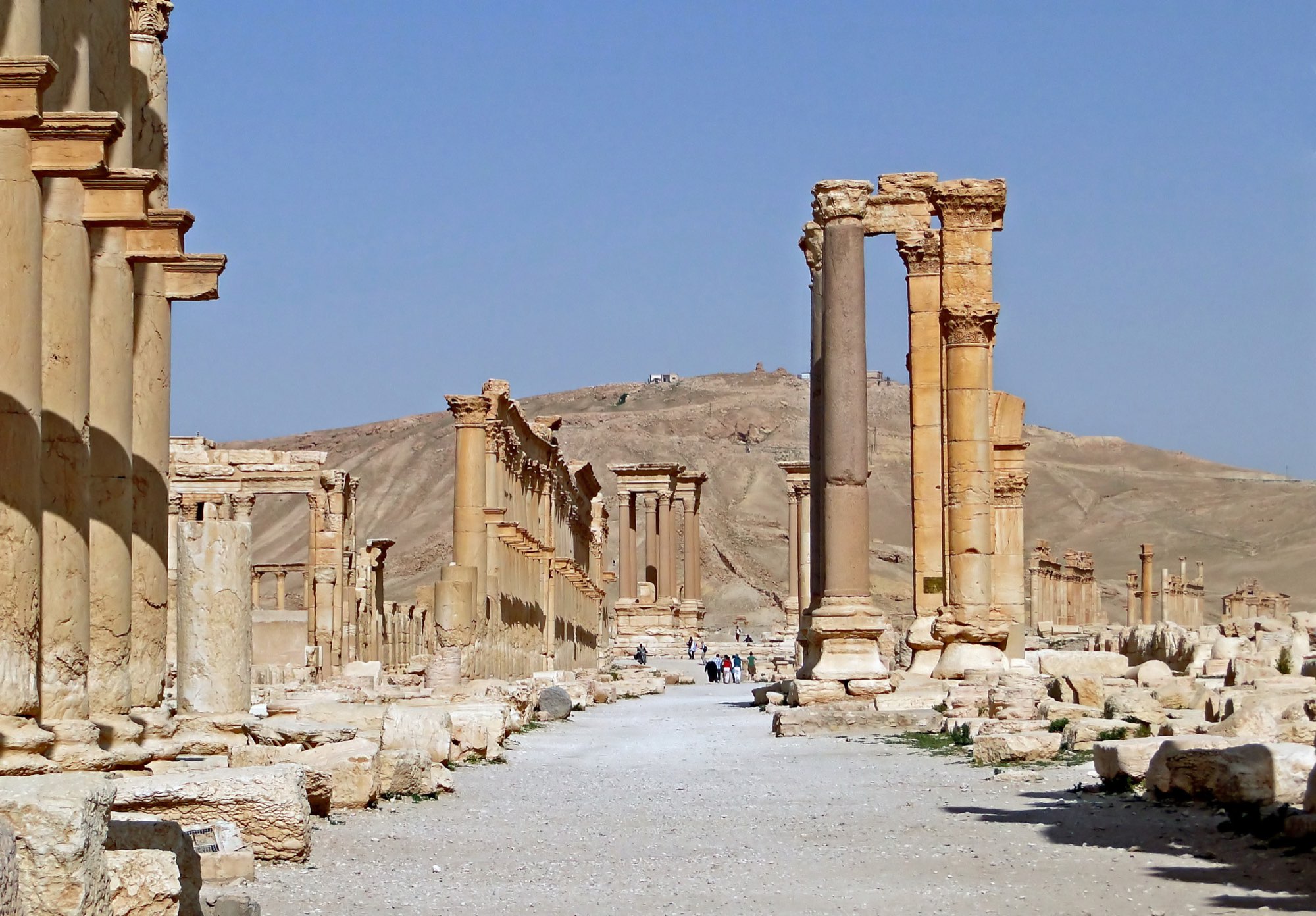 Søjlegaden i Palmyra, med rækker af søjler langs vejen og en bakke i baggrunden.